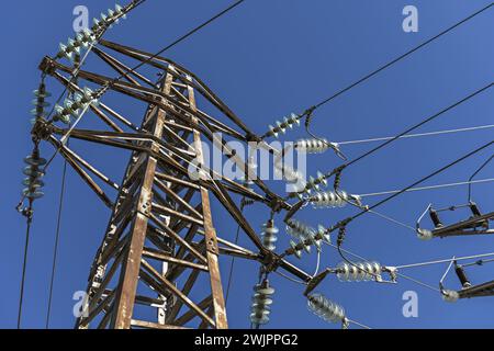Una torre ad alta tensione che trasporta elettricità attraverso i suoi cavi con isolatori per campana Foto Stock