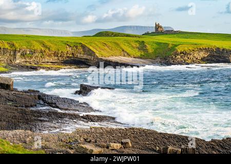 Famoso castello di Classiebawn nel pittoresco paesaggio di Mullaghmore Head. Spettacolare vista del tramonto con enormi onde che si infrangono a terra. Punto di firma di Wil Foto Stock