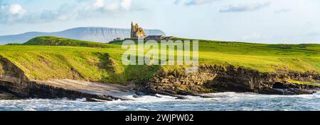 Famoso castello di Classiebawn nel pittoresco paesaggio di Mullaghmore Head. Spettacolare vista del tramonto con enormi onde che si infrangono a terra. Punto di firma di Wil Foto Stock