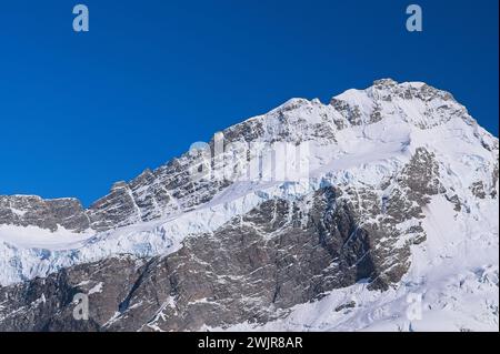 Primo piano di Icy Mountain: Splendide vette innevate contro un vivace cielo blu Foto Stock