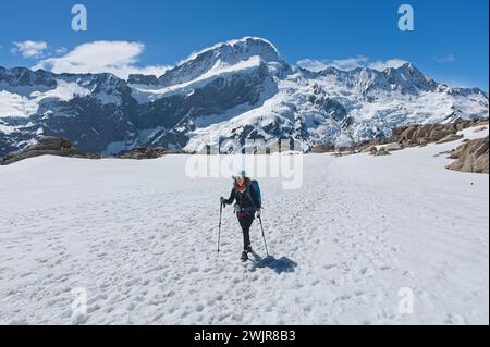 Una donna affronta il paesaggio ghiacciato della regione di Mount Cook in nuova Zelanda mentre cammina attraverso le formazioni rocciose glaciali Foto Stock