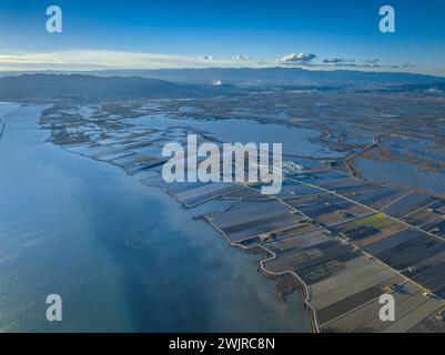 Vista aerea della zona umida dell'Encanyissada, delle risaie e della baia di Alfacs al tramonto nel Delta dell'Ebro (Tarragona, Catalogna, Spagna) Foto Stock