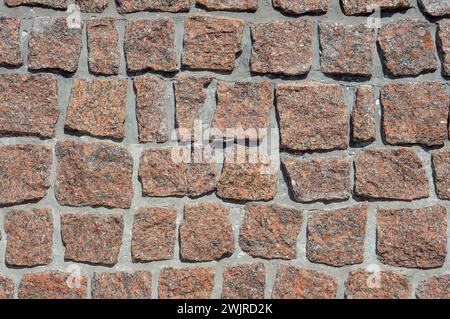 Questa foto mostra un primo piano dettagliato di un muro in mattoni costruito utilizzando mattoni singoli. I mattoni sono disposti in un motivo che mostra la consistenza Foto Stock