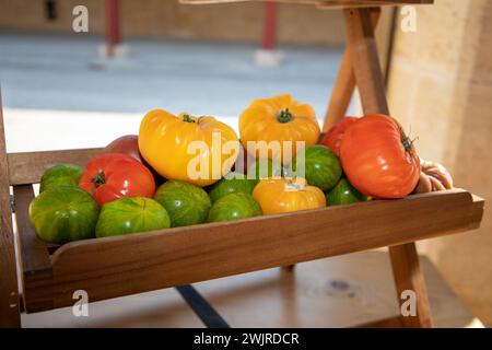 Assortimento di varietà di pomodori maturi in esposizione in legno sul mercato locale all'aperto Foto Stock