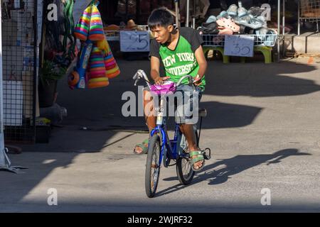 SAMUT PRAKAN, THAILANDIA, DEC 07 2023, Un giovane ciclista cavalca attraverso il mercato Foto Stock