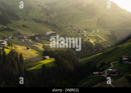 Una vista panoramica dell'idilliaco villaggio annidato tra verdi montagne a Warth, Austria. Foto Stock