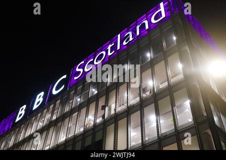 Glasgow Scozia: 11 febbraio 2024: Fiume Clyde di notte con l'edificio della BBC Scotland illuminato con la felicità dell'acqua. BBC Pacific Quay Foto Stock