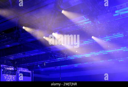 Luce ambiente e faretti in una stanza buia che splende dal soffitto Foto Stock