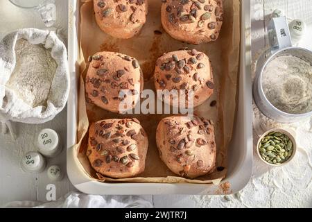 Panini fatti in casa con semi di zucca e ingredienti in tavola. Panini cotti in una panetteria. Foto Stock