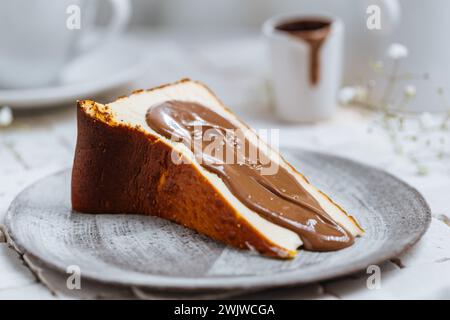 Popolare dessert spagnolo chiamato San Sebastian cheesecake. cheesecake basca bruciata. Un pezzo di torta su sfondo bianco con glassa di cioccolato. Foto Stock