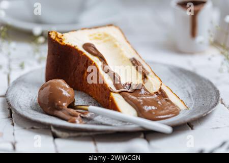 Popolare dessert spagnolo chiamato San Sebastian cheesecake. cheesecake basca bruciata. Un pezzo di torta su sfondo bianco con glassa di cioccolato. Foto Stock