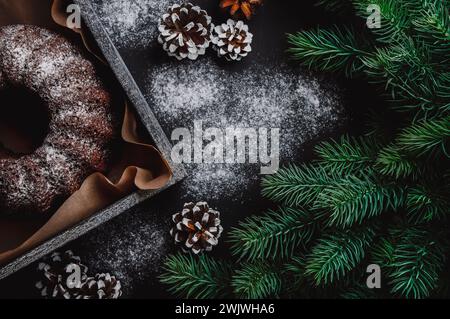 Anello di cioccolato cotto appositamente per Natale con spezie, cannella, vaniglia, chiodi di garofano, zenzero. Cuocere tra i rami di abete rosso. Delizioso cioccolato CA Foto Stock