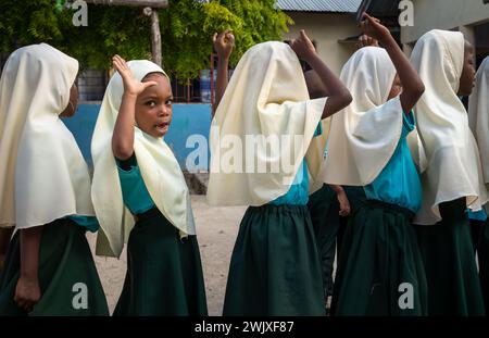 Giovani ragazze musulmane alla riunione mattutina alla scuola elementare Jambiani di Jambiani, Zanzibar, Tanzania. Foto Stock