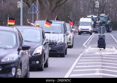 Duesseldorf, Germania. 17 febbraio 2024. Diverse auto con bandiere tedesche guidano lungo una strada a Düsseldorf durante una manifestazione contro il governo tedesco. L'alleanza "DEMO 2,0 - insieme per un futuro sicuro" prevede di dimostrare a Düsseldorf sotto forma di un raduno di 24 ore. Con 1700 trattori, autocarri e automobili previsti, ci sarà anche una sfilata di veicoli sia il sabato che la domenica. I punti di incontro saranno i parcheggi fieristici. Il corteo è previsto per le 16 di sabato. Crediti: David Young/dpa/Alamy Live News Foto Stock