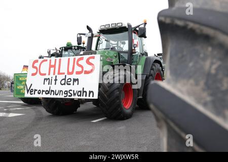 Duesseldorf, Germania. 17 febbraio 2024. Un trattore con la scritta "Schluss MIT DEM Ordnungswahn" è in viaggio durante una manifestazione contro il governo federale di Düsseldorf. L'alleanza "DEMO 2,0 - insieme per un futuro sicuro" prevede di dimostrare a Düsseldorf sotto forma di un raduno di 24 ore. Con 1700 trattori, autocarri e automobili previsti, ci sarà anche una sfilata di veicoli sia il sabato che la domenica. I punti di incontro saranno i parcheggi fieristici. Il corteo è previsto per le 16 di sabato. Crediti: David Young/dpa/Alamy Live News Foto Stock