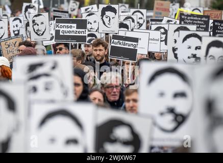 Hanau, Germania. 17 febbraio 2024. Le persone marciano attraverso il centro della città durante una marcia commemorativa per celebrare il quarto anniversario dell'attacco razzista a Hanau. Molti ritraggono le foto delle vittime. Credito: Boris Roessler/dpa/Alamy Live News Foto Stock