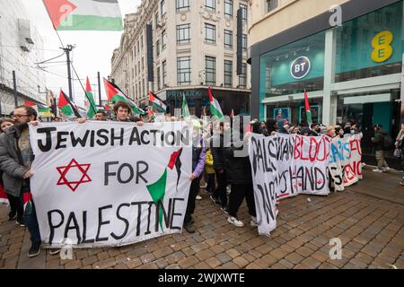 Manchester, Regno Unito. 17 febbraio 2024. Protesta palestinese a Gaza nel centro di Manchester. I manifestanti hanno marciato attraverso il centro della città monitorato dalla polizia. I manifestanti si fermarono e alzarono le mani con guanti coperti di vernice rossa per indicare la protesta che Barclays Bank aveva le mani sporche di sangue per quanto riguarda il conflitto in corso. La marcia ha trattenuto tram e traffico mentre migliaia di persone hanno marciato pacificamente. Manchester Regno Unito. Crediti: GaryRobertsphotography/Alamy Live News Foto Stock