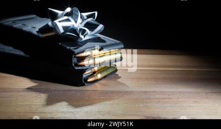 Due caricatori di fucili d'assalto ad alta capacità e completamente caricati sotto un arco d'argento come regalo per un proprietario di armi il giorno del papà, un compleanno o Christma Foto Stock