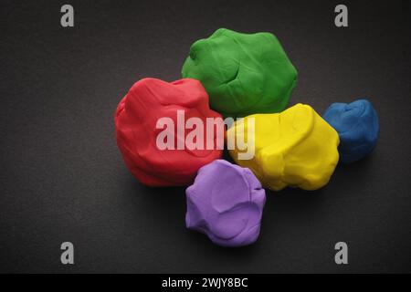 Palline colorate di plastica adagiate su una superficie nera. Primo piano. Foto Stock