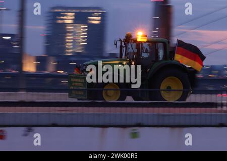 Duesseldorf, Germania. 17 febbraio 2024. Un trattore attraversa il ponte Oberkassel durante una dimostrazione contro il governo federale a Düsseldorf. L'alleanza "DEMO 2,0 - insieme per un futuro sicuro" prevede di dimostrare a Düsseldorf sotto forma di un raduno di 24 ore. Sabato e domenica si terrà una sfilata di trattori, camion e auto. Crediti: David Young/dpa/Alamy Live News Foto Stock