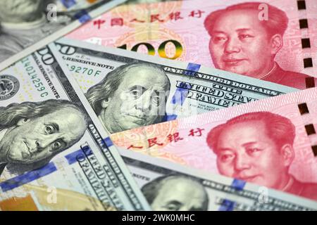 Dollari USA circondati da banconote cinesi in yuan. Concetto di guerra commerciale tra Cina e USA, economica, sanzioni Foto Stock