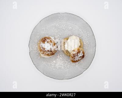 Una prospettiva dall'alto di una classica semola svedese, nota anche come fastlagsbulle, decorata con panna montata, pasta di mandorle e zucchero a velo, elegante Foto Stock