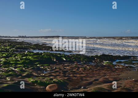 Il porto con le onde della marea primaverile sulla spiaggia di Maryport, Cumbria, Regno Unito Foto Stock