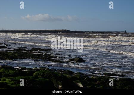 Il porto con le onde della marea primaverile sulla spiaggia di Maryport, Cumbria, Regno Unito Foto Stock