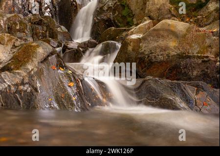 Catturando l'eterea bellezza dell'acqua fluente, questa fotografia impiega una tecnica di esposizione lunga, che produce una sfocatura ipnotizzante che evoca un senso Foto Stock