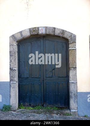 Vecchia porta di legno blu su una facciata bianca e blu Foto Stock