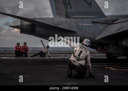 PHILIPPINE SEA (15 febbraio 2024) i marinai statunitensi si preparano a lanciare un F/A-18E Super Hornet, attaccato al "Flying Checkmates" dello Strike Fighter Squadron (VFA) 211, fuori dal ponte di volo della portaerei classe Nimitz USS Theodore Roosevelt (CVN 71), 15 febbraio 2024. La Theodore Roosevelt, nave ammiraglia del Carrier Strike Group Nine, sta conducendo operazioni di routine nell'area delle operazioni della 7th Fleet. Parte integrante della U.S. Pacific Fleet, la U.S. 7th Fleet gestisce le forze navali nell'Indo-Pacifico e fornisce l'addestramento realistico e pertinente necessario per eseguire il ruolo della US Navy Foto Stock