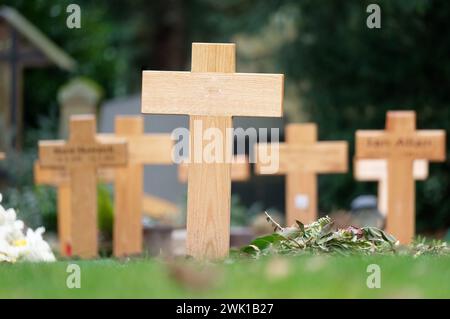 molte croci di legno su una tomba fresca in un cimitero per i poveri Foto Stock