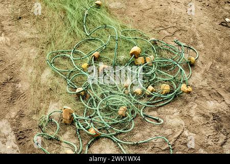 Reti da pesca e galleggianti sono tutti aggrovigliati in un mucchio sulla spiaggia vicino al mercato del pesce Chorillos a Lima, in Perù. Foto Stock