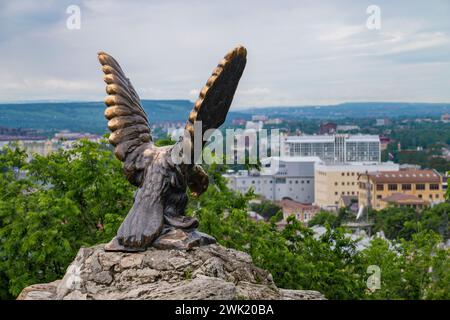 PYATIGORSK, RUSSIA - 07 GIUGNO 2023: Scultura dell'aquila sullo sfondo di un paesaggio urbano su una nuvolosa mattina di giugno. Acque minerali caucasiche Foto Stock