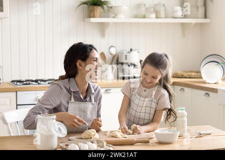 Mamma e bambino ridendo preparano dolci fatti in casa in cucina Foto Stock