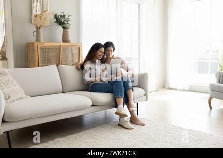 Figlia adulta e madre matura che utilizzano un tablet digitale Foto Stock