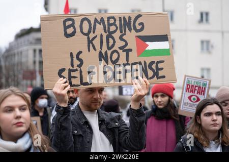 Varsavia, Polonia. 17 febbraio 2024. Un uomo ha uno striscione che dice "bombardare bambini non è autodifesa” al raduno di solidarietà con la Palestina a Varsavia. Centinaia di manifestanti pro-palestinesi si sono riuniti nel centro di Varsavia per protestare. Durante la manifestazione, la folla ha cantato slogan come "Palestina libera” e ha criticato Israele definendolo uno "Stato terroristico”. Credito: SOPA Images Limited/Alamy Live News Foto Stock