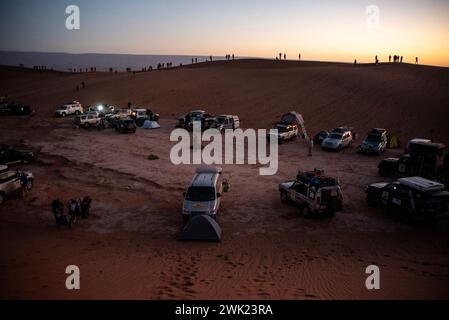 Erg Chigaga, Marocco. 1 febbraio 2024. I piloti guardano l'alba da una duna nel deserto del Sahara a Erg Chigaga, in Marocco. Il rally amatoriale Budapest-Bamako ha celebrato la quindicesima corsa. È iniziato il 30 gennaio da FES, Marocco, e terminerà il 12 febbraio a Freetown, Sierra Leone. Il percorso originale è stato riorganizzato per ovvi motivi di sicurezza proprio come nella gara Parigi-Dakar, ma allo stesso tempo la distanza è stata estesa. Nel corso degli anni il rally amatoriale Budapest-Bamako è diventato una delle gare più lunghe e impegnative del mondo. (Immagine di credito: © Krisztian E. Foto Stock