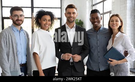 Ritratto di gruppo di colleghi felici e sorridenti in un moderno ufficio leggero Foto Stock