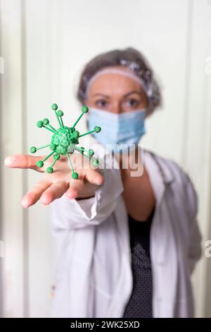 Medico donna in possesso di un modello della corona coronavirus Foto Stock