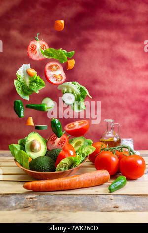 un mucchio di verdure cadute su un piatto con insalata su un tavolo di legno con una padella dell'olio e uno shaker di sale e fondo Foto Stock