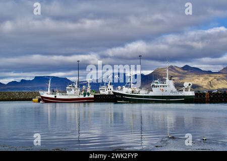 Villaggio di Grindavik, porto nordico con barca da pesca e montagne con neve sullo sfondo nel nord dell'Islanda Foto Stock