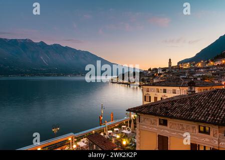 Ammira la città di Limone, il Lago di Garda e il Monte Baldo al tramonto, la Lombardia, l'Italia Foto Stock