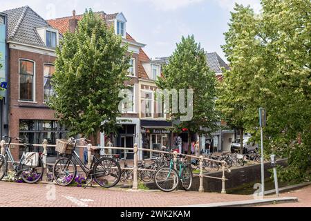 Piacevole via dello shopping lungo il canale nel centro della città di Leeuwarden in Frisia. Foto Stock