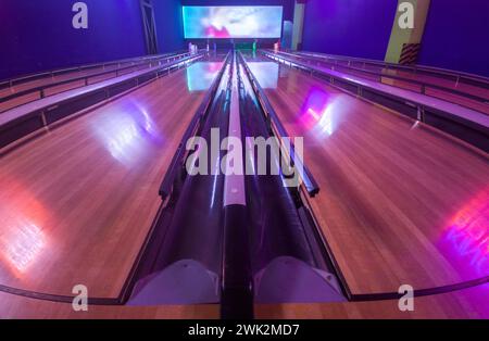 Pista da bowling a quattro corsie con paraurti per bambini e principianti. Queste barriere sporgono dal gocciolatoio delle palle Foto Stock