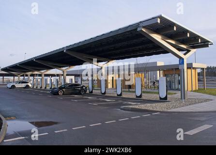 Berlino, Germania - 4 febbraio 2024: Una foto statica della ricarica Tesla Model 3 e Y presso le stazioni di ricarica Gigafactory Supercharger e CA in una soleggiata giornata invernale. Se Foto Stock