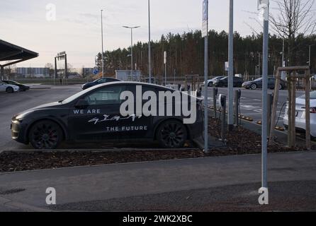 Berlino, Germania - 4 febbraio 2024: Una foto statica della ricarica Tesla Model 3 e Y presso le stazioni di ricarica Gigafactory Supercharger e CA in una soleggiata giornata invernale. Se Foto Stock