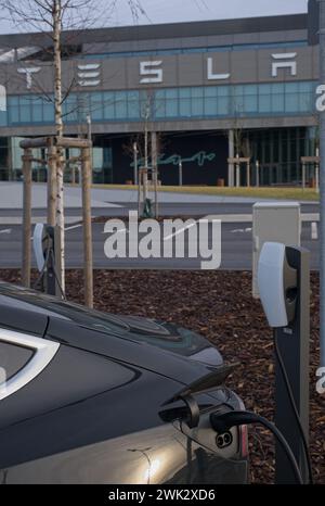 Berlino, Germania - 4 febbraio 2024: Una foto statica della ricarica Tesla Model 3 e Y presso le stazioni di ricarica Gigafactory Supercharger e CA in una soleggiata giornata invernale. Se Foto Stock