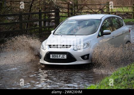 Eton, Windsor, Regno Unito. 18 febbraio 2024. Gli automobilisti guidano attraverso le acque alluvionali in un paese di Eton, Windsor, Berkshire dopo una forte pioggia notturna. Crediti: Maureen McLean/Alamy Live News Foto Stock