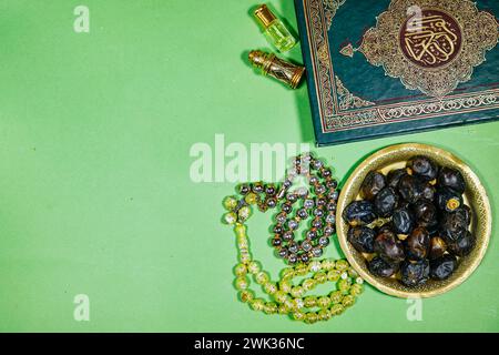 Libro musulmano con calligrafia araba traduzione del Corano : libro sacro di musulmani e oud profumo e censore, datteri frutto, tasbih. concetto iftar ramadan Foto Stock